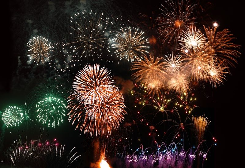 Nighttime Fireworks Over Historic Town Centers